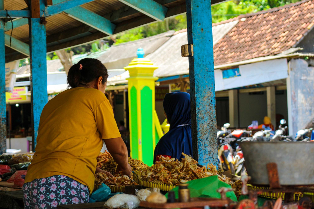 Einheimische Frau verkauft Waren auf einem traditionellen Markt in Bali