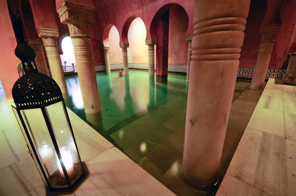 Traditionelles Hammam in Marokko mit Säulen, warmem Licht und Wasserbecken – pure Entspannung nach dem Surfen