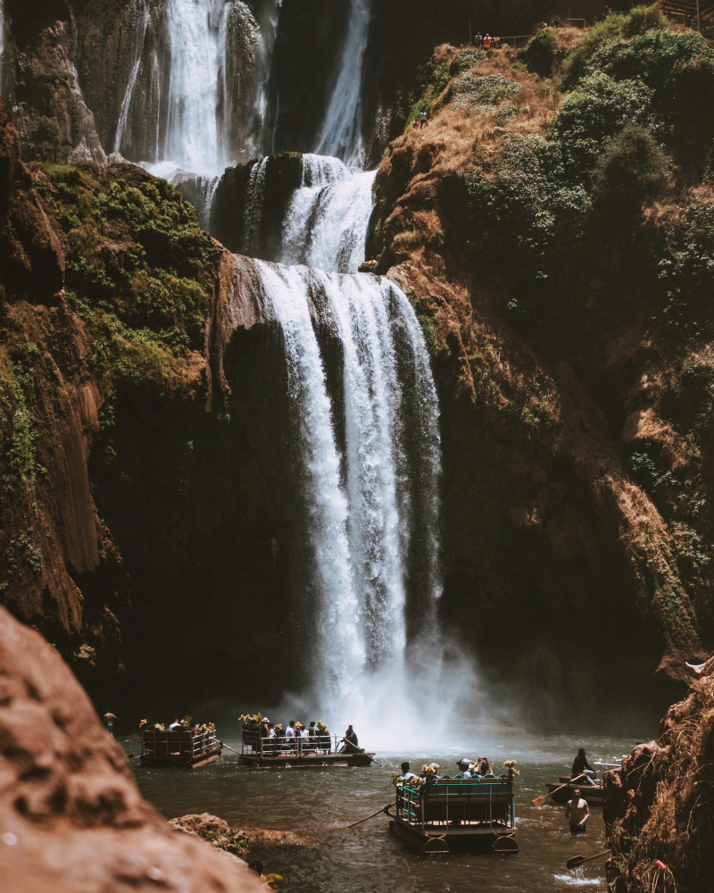 Touristen auf Booten am Fuße der Ouzoud-Wasserfälle in Marokko – Naturerlebnis und Ausflug ab Marrakesch