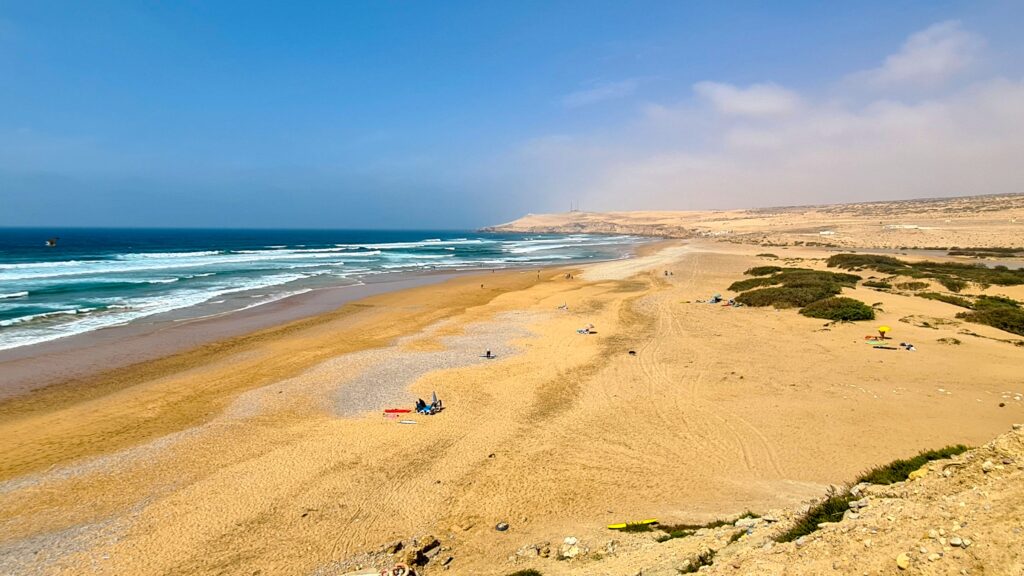 Weitläufiger Sandstrand an der Atlantikküste von Marokko mit Wellen und unberührter Natur