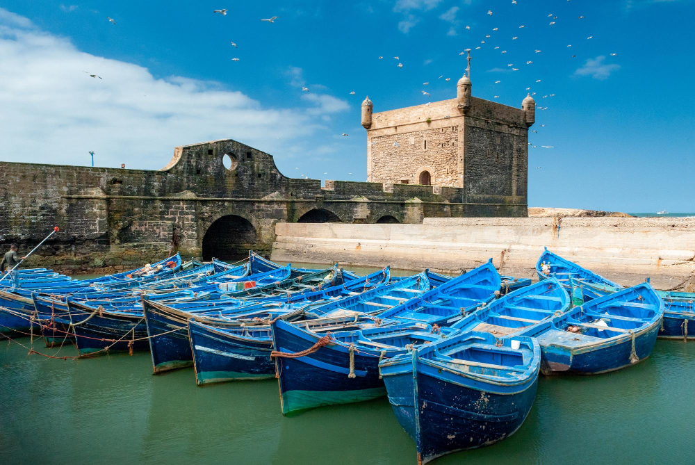 Blick auf den Hafen von Essaouira in Marokko mit den typischen blauen Fischerbooten und der historischen Festung