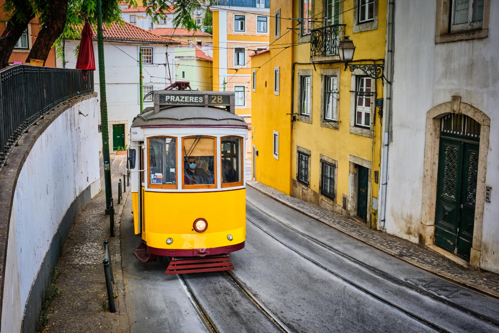 Gelbe Straßenbahn in den verwinkelten Gassen von Lissabon, ein Wahrzeichen der Stadt