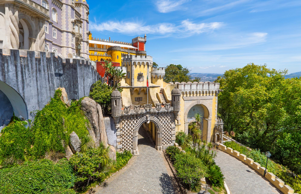 Bunter Pena-Palast in Sintra, umgeben von grüner Natur – märchenhafte Architektur und UNESCO-Weltkulturerbe in Portugal.