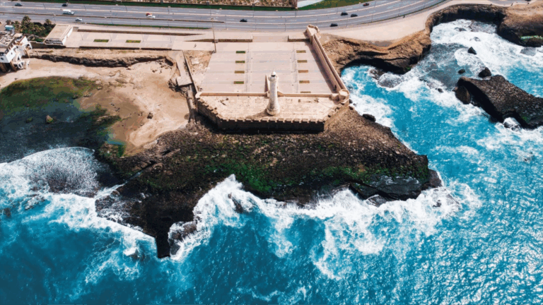 Leuchtturm an der Atlantikküste von Rabat in Marokko mit tosenden Wellen – eindrucksvolles Wahrzeichen und Startpunkt für Surfer