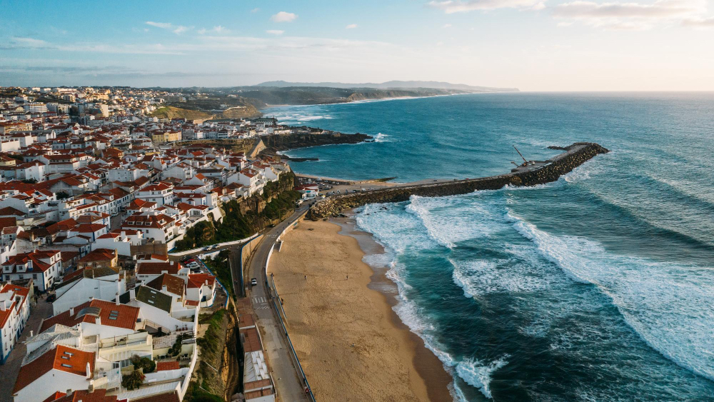 Luftaufnahme der Surfregion um Lissabon mit Ericeira und Peniche – weiße Häuser am Meer und perfekte Wellen für Surfer
