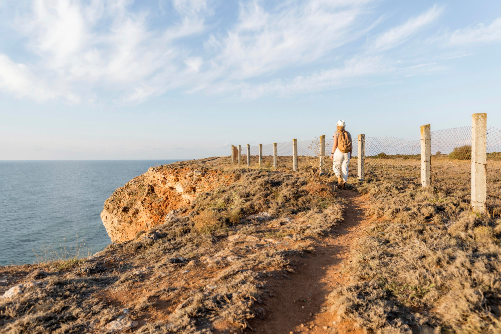 Wanderer auf einem Küstenpfad an den dramatischen Klippen der Algarve mit Blick auf den Atlantik